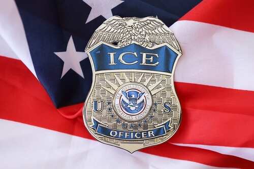 ICE officer badge placed on an American flag
