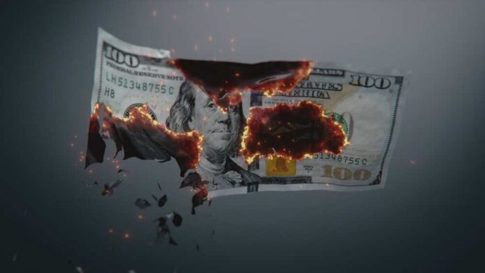 A hundred dollar bill appearing to burn and disintegrate