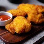 Crispy fried chicken pieces served with a small bowl of ketchup