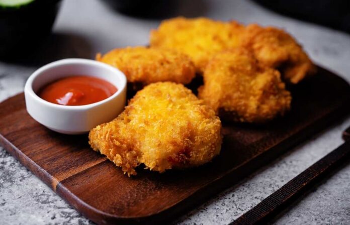 shutterstock_2646168299.jpg Crispy fried chicken pieces served with a small bowl of ketchup