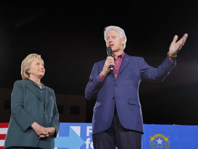 Hillary Clinton and Bill Clinton speaking at a political rally