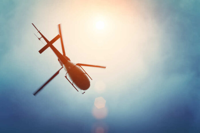 shutterstock_465605396.jpg A helicopter flying against a bright sky