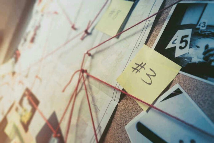 Investigation board with photos, notes, and red string.