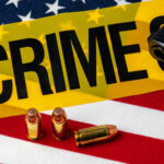 A gun and bullets on an American flag with a crime scene marker