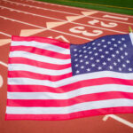 American flag waving in front of a running track