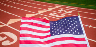 American flag waving in front of a running track
