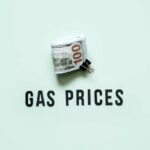 A bundle of cash next to the words 'GAS PRICES' on a light green background