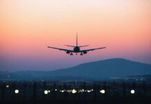 American Airports Reach Breaking Point An airplane approaching for landing against a colorful sunset sky