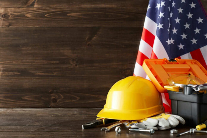 Yellow hard hat and tools with American flag.