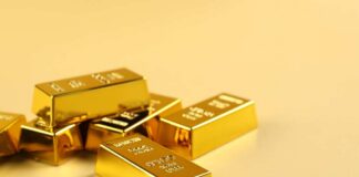 Several gold bars stacked on a golden surface