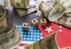 Dollar bills surrounding wooden blocks spelling 'WAR' on flags of the USA and China