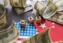 Dollar bills surrounding wooden blocks spelling 'WAR' on flags of the USA and China