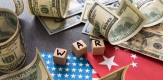 Dollar bills surrounding wooden blocks spelling 'WAR' on flags of the USA and China