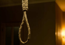 A close-up of a noose hanging in a dimly lit room