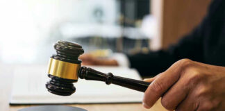Gavel in judges hand about to strike.