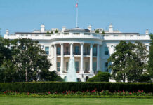 The White House, front view with fountain and flag.