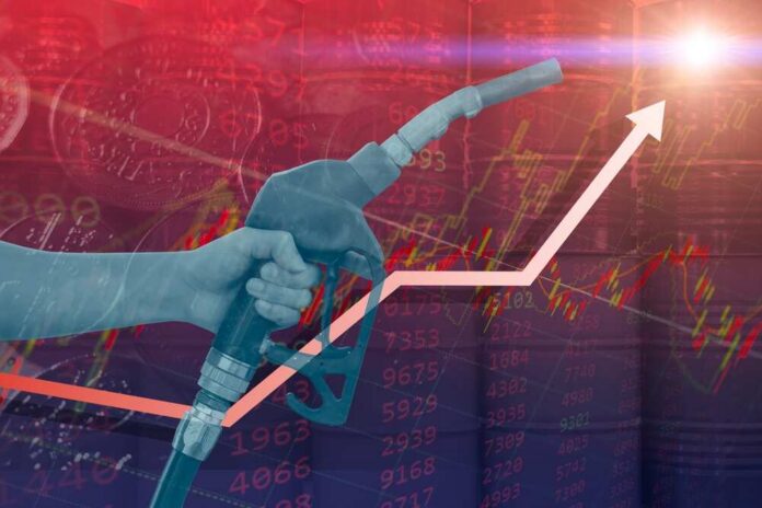 Hand holding a fuel nozzle with rising graph lines in the background