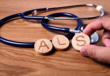 Experimental ALS Cure Sparks Hope A hand holding wooden letters 'A', 'L', and 'S' next to a stethoscope on a wooden surface