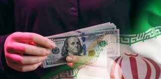 A person holding a stack of US hundred-dollar bills in front of the Iranian flag