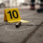 Bullet casing on the ground next to a numbered evidence marker