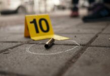 Bullet casing on the ground next to a numbered evidence marker