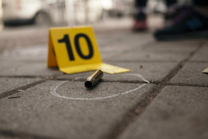 Bullet casing on the ground next to a numbered evidence marker