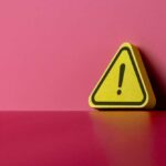 Bus Bombing Massacre Shakes Country Yellow triangular warning sign on a pink background