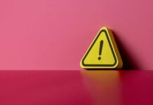 Yellow triangular warning sign on a pink background