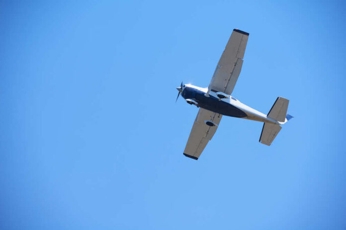 An airplane flying against a clear blue sky