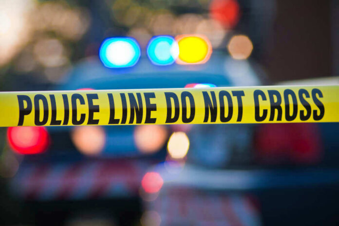 shutterstock_56280433.jpg Police tape and lights at crime scene.
