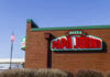 Exterior view of a Papa John's pizza restaurant with a flag in the background