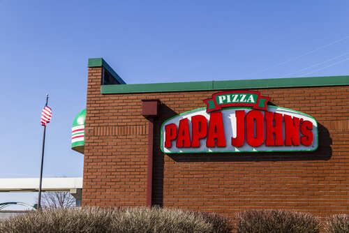 Exterior view of a Papa John's pizza restaurant with a flag in the background