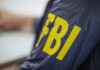 Person wearing FBI jacket, letters in yellow.