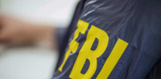 Person wearing FBI jacket, letters in yellow.