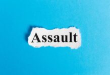 The word 'Assault' printed on torn paper against a blue background