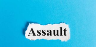 The word 'Assault' printed on torn paper against a blue background