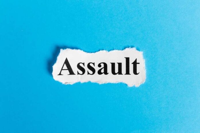 The word 'Assault' printed on torn paper against a blue background
