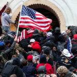 Controversy: JAN 6 Cops Sue DOJ Crowd storming a building, waving an American flag.