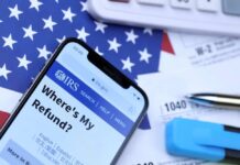 Smartphone displaying IRS website with tax documents and American flag in the background