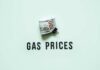 A bundle of cash next to the words 'GAS PRICES' on a light green background