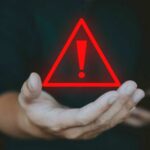 ICONIC Search Engine DEAD A hand holding a red warning triangle with an exclamation mark