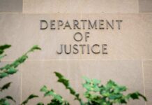 $250M Bribery Case DISMISSED by DOJ Sign displaying 'Department of Justice' on a stone wall