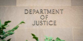 Sign displaying 'Department of Justice' on a stone wall