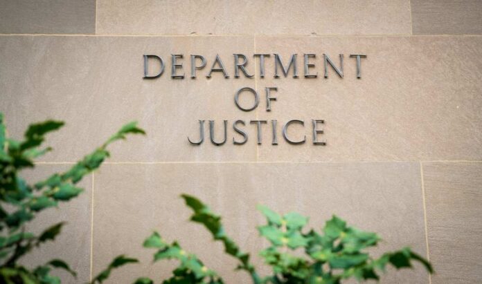 The,United,States,Department,Of,Justice,(doj),In,Washington,D.c., Sign displaying 'Department of Justice' on a stone wall