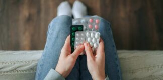 Person holding multiple blister packs of pills