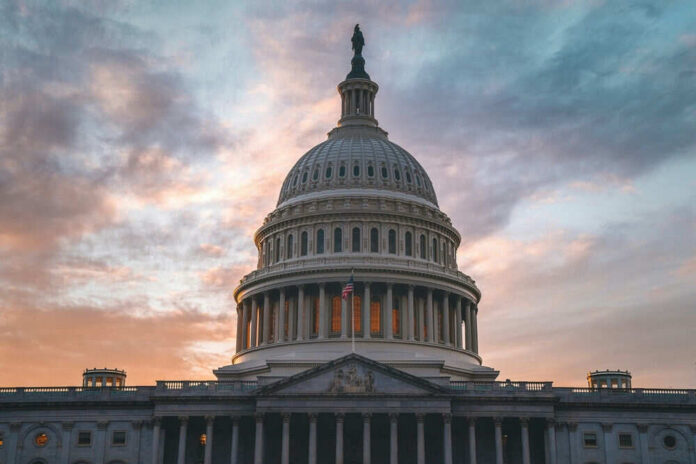 shutterstock_2470608247 Capitol building under cloudy sunset sky