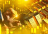 Hand writing near stacked gold bars and charts