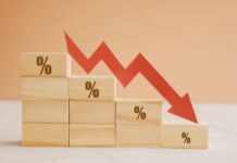 Electric Car Gamble Ends in HUGE, HISTORIC LOSS Wooden blocks with percentage symbols and a downward arrow indicating decline