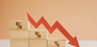 Wooden blocks with percentage symbols and a downward arrow indicating decline