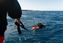 Deadly Dive: Maldivian Cave Mystery Two scuba divers in the ocean being assisted by a person holding a rescue line